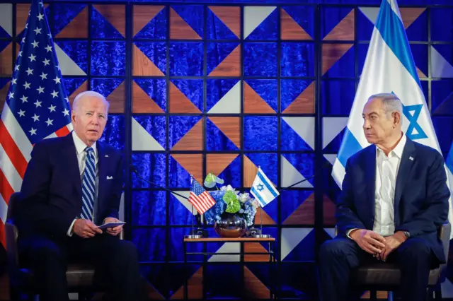 Biden and Netanyahu sit in front of their respective country's flags at a press conference