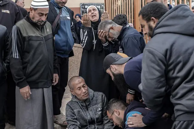 A grieving family pictured in Khan Younis on Wednesday after alleged Israeli air strikes