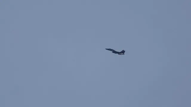 An Israeli military fighter jet flies over the Israeli side of the border with Gaza