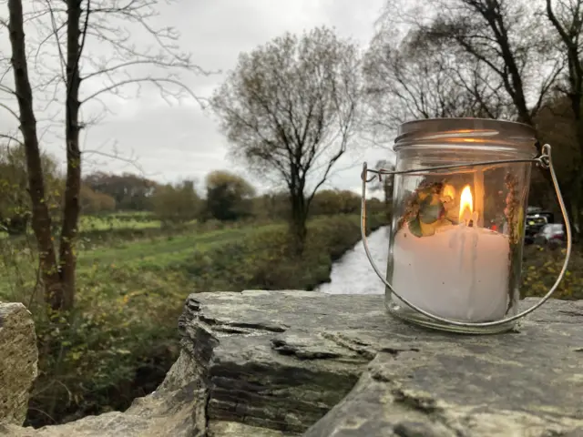 Single candle lit on a bridge