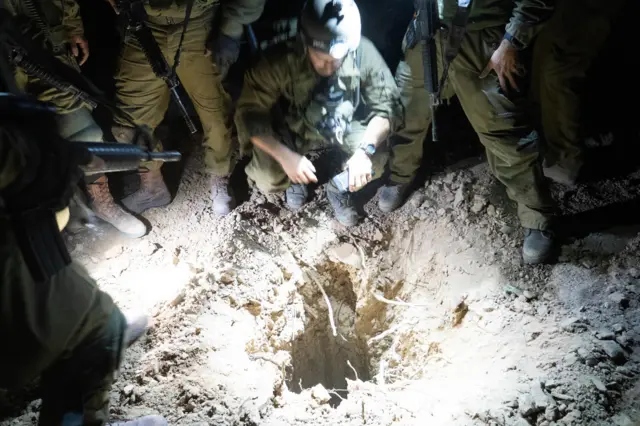 IDF soldiers crowd around a tunnel shaft