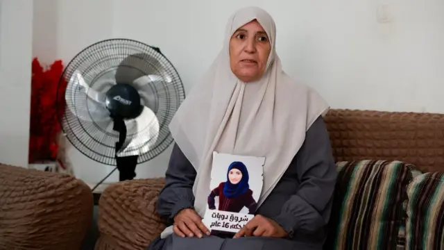 Sameera Dwayatt holding a picture of her daughter Shorouq