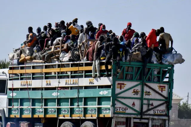 IDPs stand on a lorry toward the gate of the Bakassi IDPs Camp before leaving to their respective home in Maiduguri on November 30, 2021 as Internally Displaced Persons (IDPs) in Maiduguri have vacated their camps ahead of today, dateline for the closure of all Displaced Persons camps by the Borno Government.