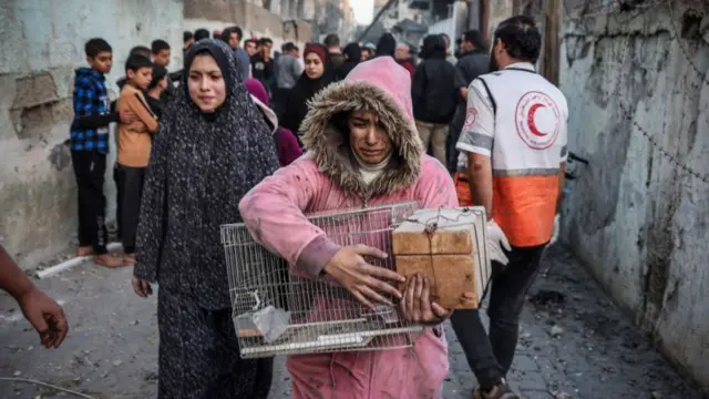 A woman carrying a cage cries