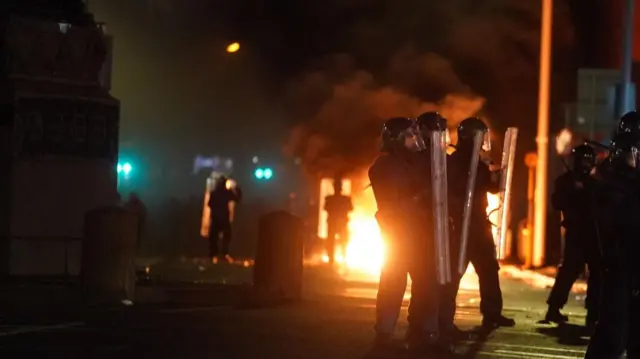 Riot police and a burning vehicle in Dublin