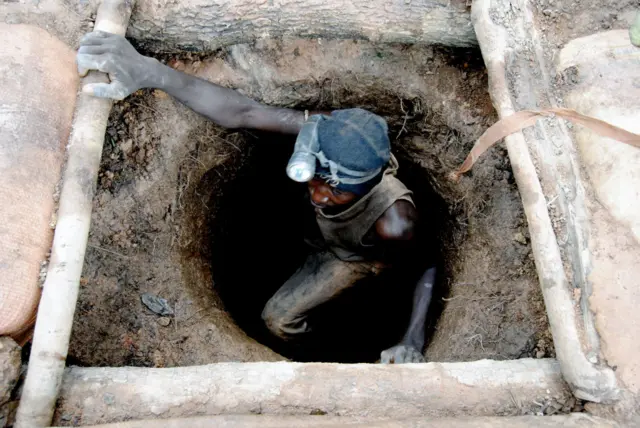 A Malian gold panner coming out of an underground mine at an artisanal gold mining site in Sadiola (north-western Mali).