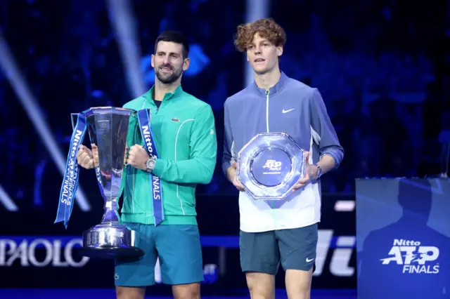 Novak Djokovic and Jannik Sinner hold their trophies at the ATP Finals