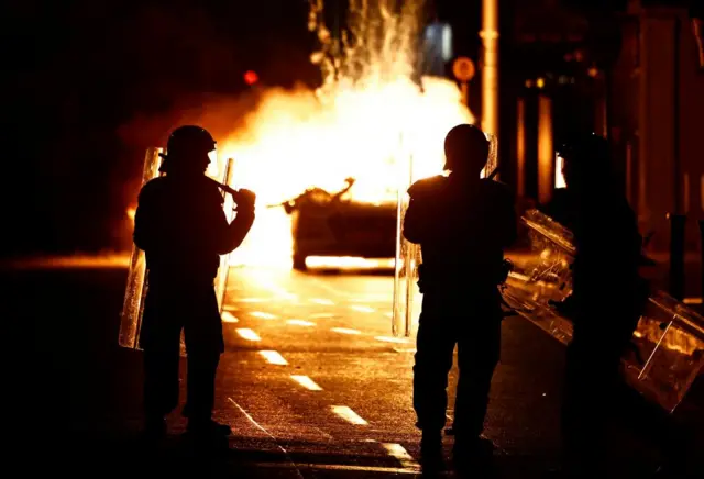 Riot police next to a burning car in Dublin city centre