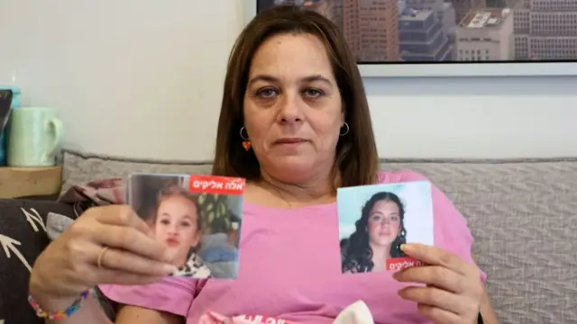 Maayan Zin holds up images of Dafna and Ela