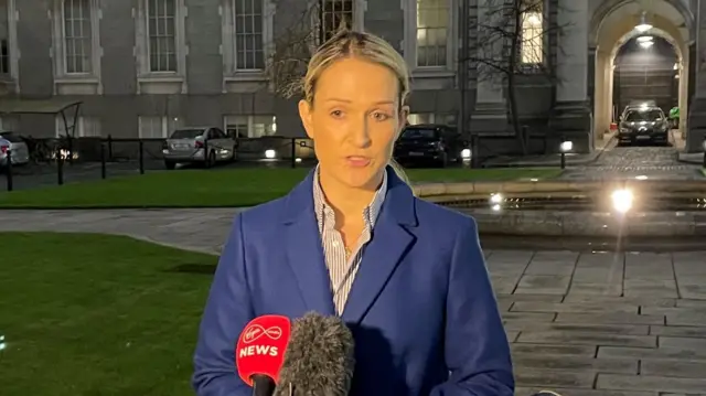 Helen McEntee speaks to the press at two microphones