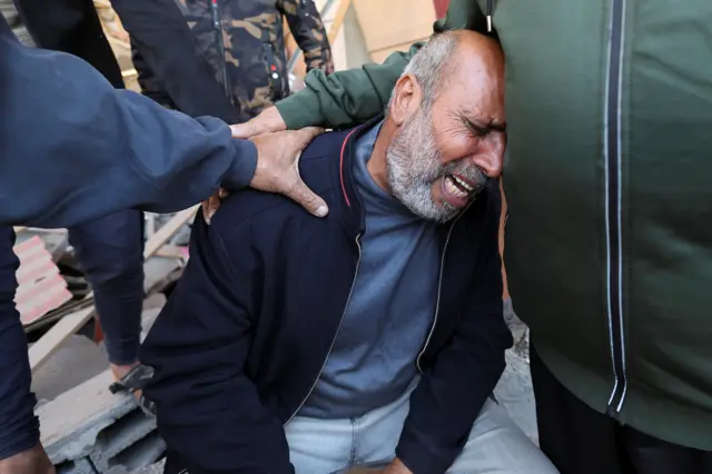 Palestinian man reacts at the site of an Israeli strike on a house in Rafah