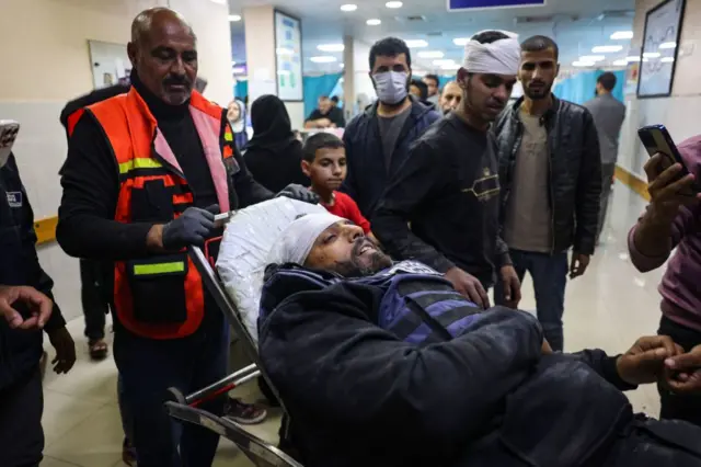 Reuters news agency cameraman Fadi Shanna arrives at a hospital after being injured while filming the destruction of a house in Khan Younis