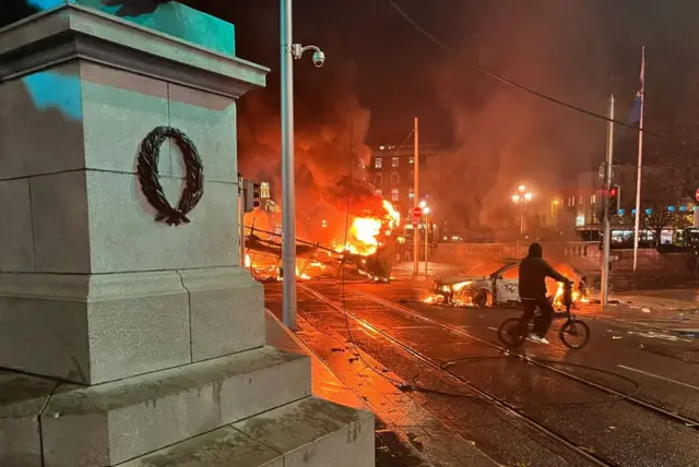 Flames rise from a car and a bus set alight in Dublin on 23 November