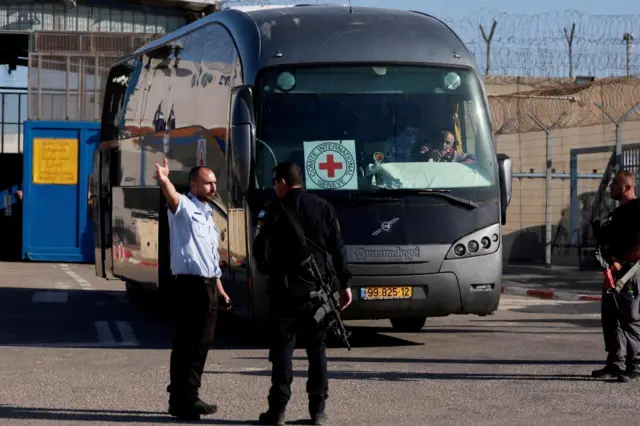 Israeli military personnel stand near a Red Cross bus outside the Israeli military prison, Ofer