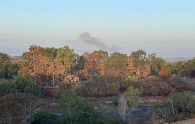 Smoke rises over the trees in Sderot