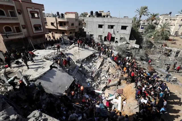 Palestinians search for casualties at the site of an Israeli strike on a house in Rafah