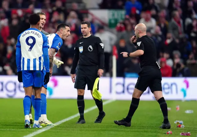 Brighton players converse with the referee.