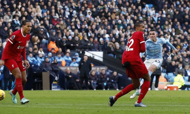 Foden takes a shot as Matip attempts to block it