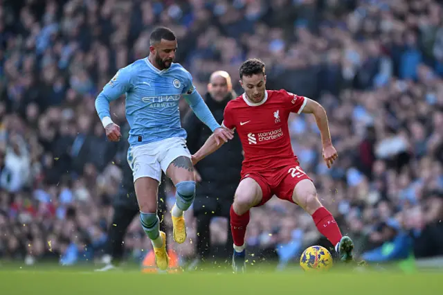 Diogo Jota of Liverpool runs with the ball whilst under pressure from Kyle Walker