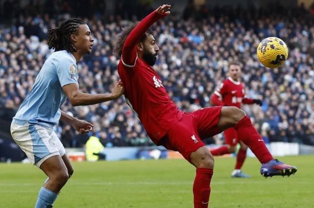 Mohamed Salah battles with Nathan Ake for the ball