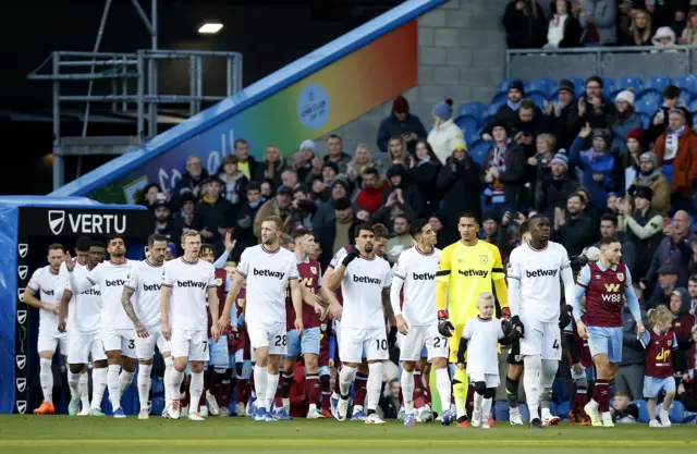 Burnley and West Ham players walk out of the tunnel.