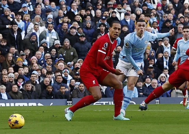 Foden takes a shot as Van Dijk looks on