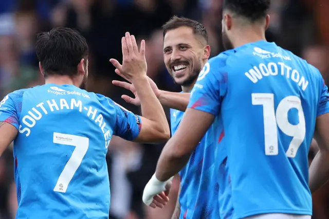 Stockport County players celebrate scoring a goal