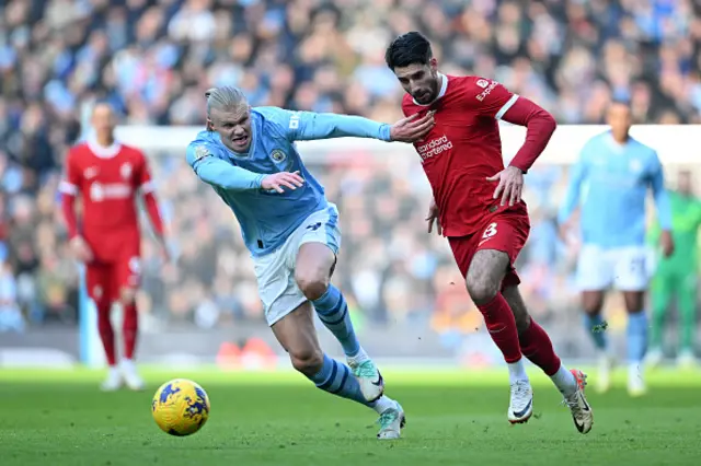 Erling Haaland of Manchester City runs with the ball whilst under pressure from Dominik Szoboszlai