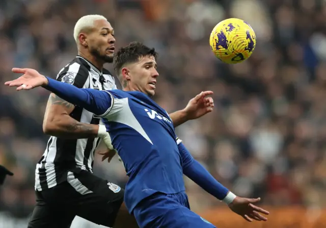 Joelinton challenges Enzo Fernandez for the ball.