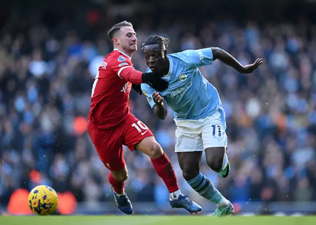 Jeremy Doku of Manchester City is challenged by Alexis Mac Allister