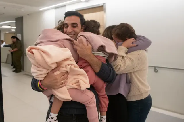 Aviv Asher, 2.5 years old, her sister Raz Asher, 4.5 years old, and mother Doron are reunited with family