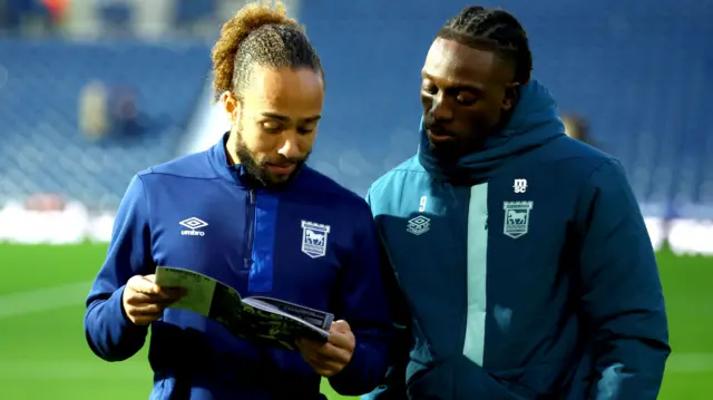 Ipswich players look at match programme