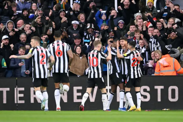 Isak celebrates with Newcastle teammates.