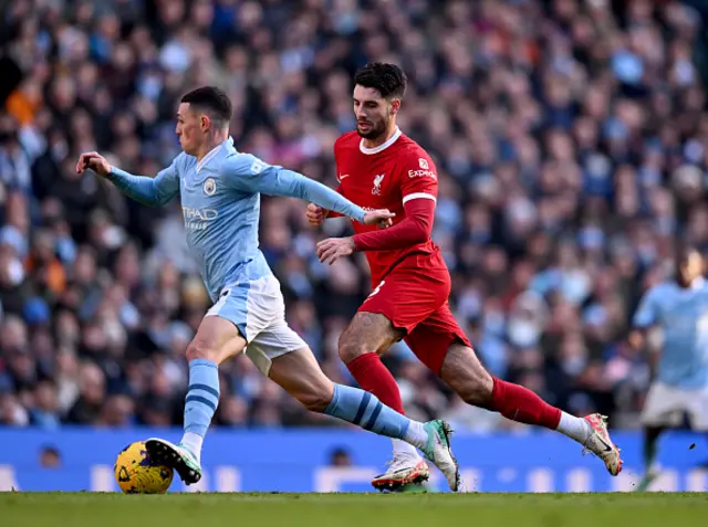 Phil Foden runs with the ball as Dominik Szoboszlai pursues him