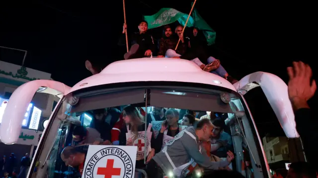 Released Palestinian prisoners wave flags as they leave the Israeli military prison