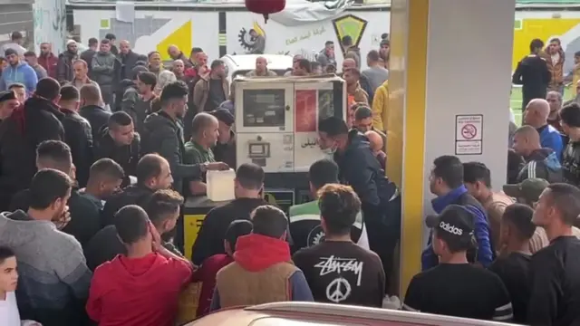 Crowds gather around the pumps of a gas station in Rafah, Gaza