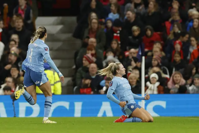 Lauren Hemp celebrates her goal at Old Trafford with a knee slide.