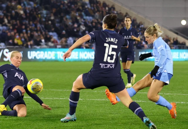 Laura Coombs takes a shot as Tottenham defenders attempt to block it