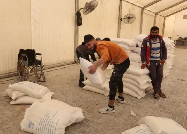 A man organises bags of flour