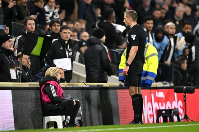 The referee goes to the monitor to check the penalty decision