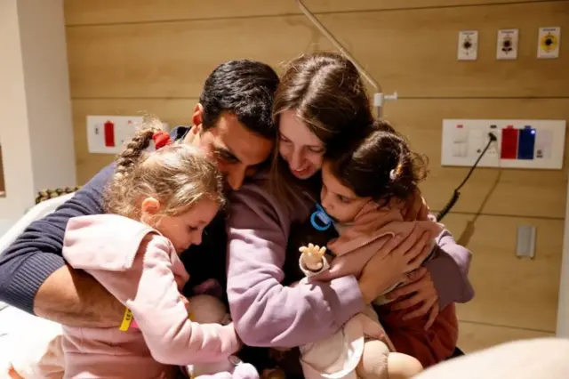 Yoni Asher embraces his wife Doron and their daughter Raz, four, and Aviv, two, after their release