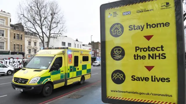 An Ambulance drives past Government (DHSC / Dept of Health and Social Care) / NHS public information campaign sign (reading Stay home, Protect the NHS, Save lives) near the Royal London hospital in London, Britain, 26 January 2021, as the National Health Service (NHS) continues to be under pressure over a sharp increase in hospital admissions in the country due to coronavirus disease (COVID-19) infection rates. The number of people who have died with coronavirus Covid-19 has exceeded 100,000 in the UK.