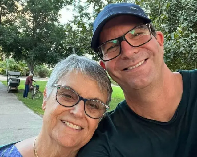 Ada and Noam smile for a selfie in the park