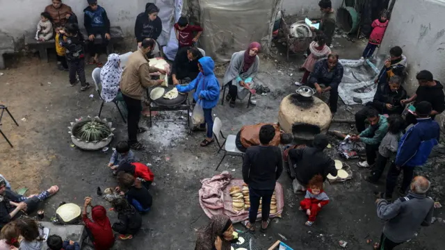 People cook at an United Nations Relief and Works Agency for Palestine Refugees (UNRWA) school in Rafah, Gaza used as a sheltering place for displaced Palestinians on November 28, 2023.