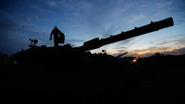 A soldier walks on an Israeli tank near the Israel-Gaza border, amid the temporary truce between Hamas and Israel, in southern Israel, November 28, 2023