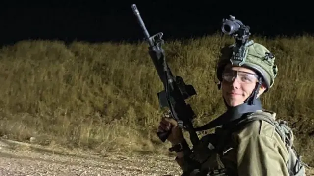 Sgt Kiril Brodski in combat gear, carrying an assault rifle