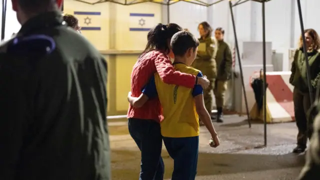 Eitan Yahalomi, 12, walks with his mother at the Kerem Shalom border crossing,