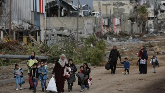 Palestinians walk after crossing from the northern Gaza Strip to the southern Gaza Strip along Salah Al Din road