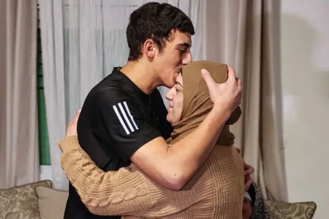 Palestinian Muhammad Abu Al-Humus, former prisoner released from the Israeli jail in exchange for hostages freed by Hamas in Gaza, kisses his mother upon return to his home in east Jerusalem, on November 28, 2023.