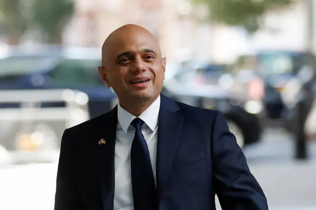 Sajid Javid smiling and walking